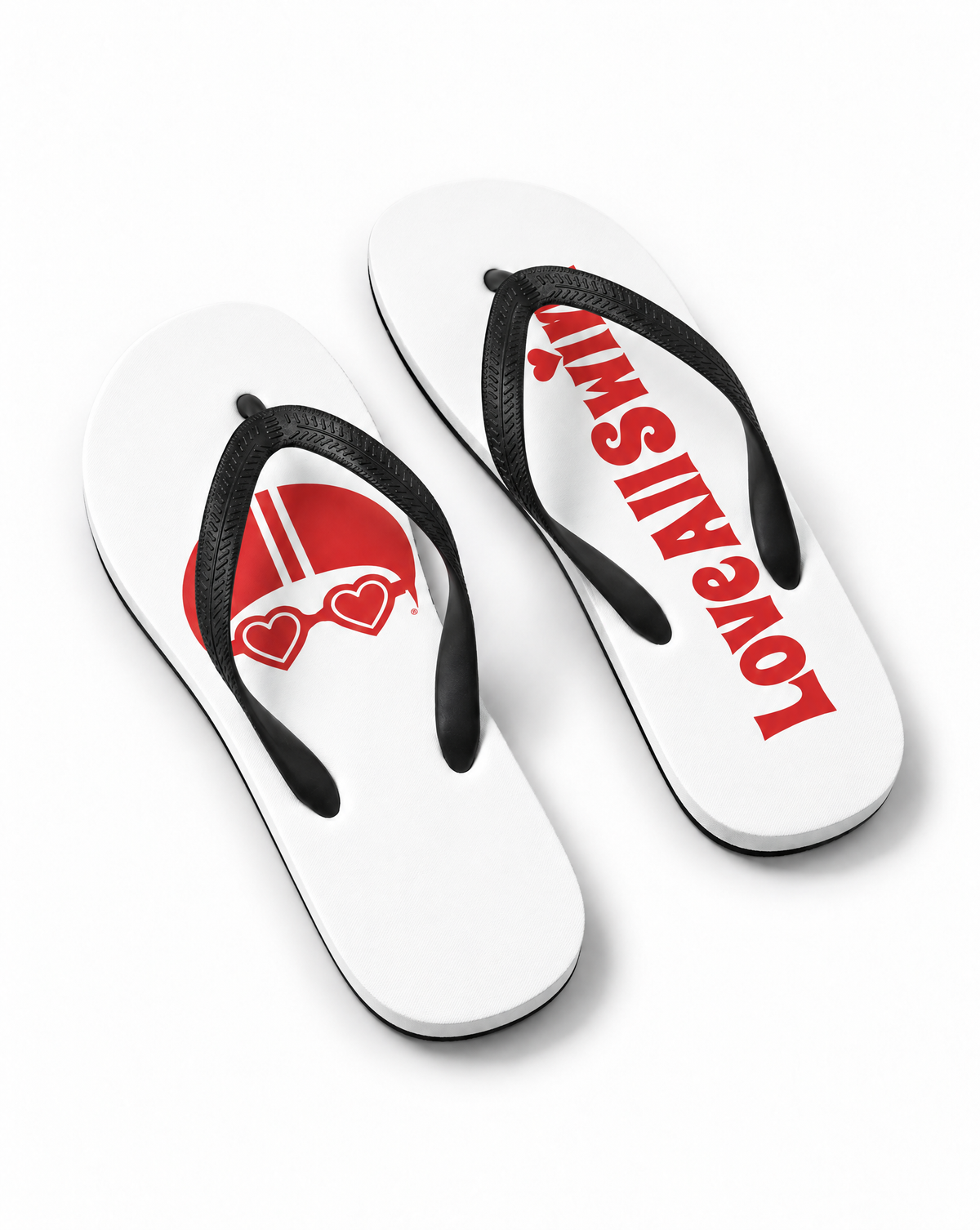 A pair of white flip-flops with black straps, featuring a red and white graphic of a helmet with heart-shaped goggles on one sandal and the word 'LOVE ALL SWIM' printed in red on the other, shown on a clean white background.